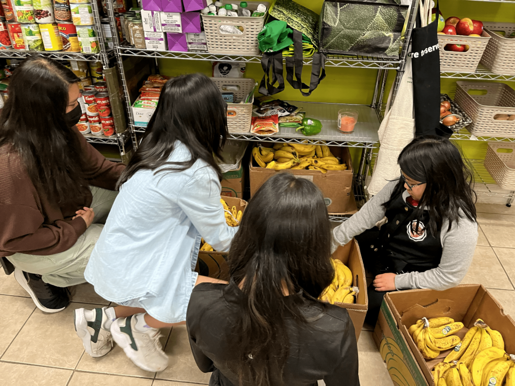 People at Good Measure Food Bank collect groceries.